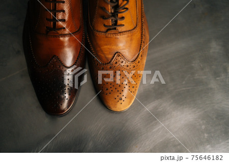 Close-up top view of old light brown leather shoe and repaired shiny shoes after restoration working. 75646182