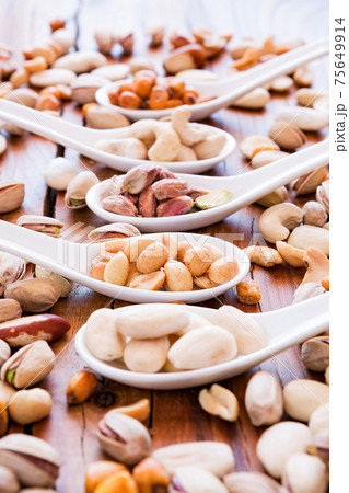 Mix of nuts over a rustic table Mix of nuts over a rustic table 75649914