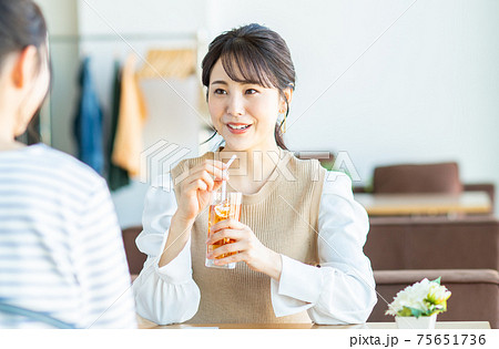 カフェで友達とお茶をする若い女性 75651736