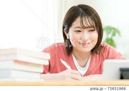 スマホでオンライン授業を受ける若い女性 75651966