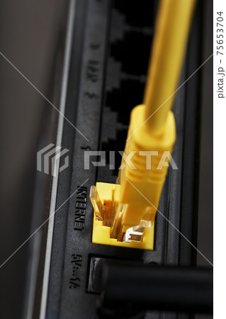 A yellow patch cord is inserted into the Wi-Fi port of the router to access the Internet. A yellow patch cord is inserted into the Wi-Fi port of the router to access the Internet. 75653704
