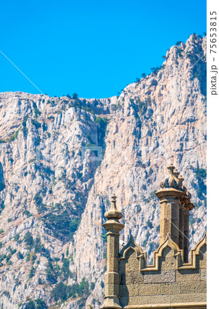 The walls and towers of the old palace on the background of high mountains and blue sky The walls and towers of the old palace on the background of high mountains and blue sky 75653815