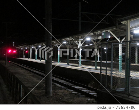 夜間の赤いライトの点いた鉄道駅のプラットホームと線路 夜間の赤いライトの点いた鉄道駅のプラットホームと線路 75654786