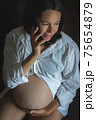From above Pregnant woman speaking on smartphone 75654879