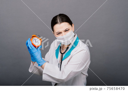 Smiling doctor woman pointing on clock, time to vaccine Smiling doctor woman pointing on clock, time to vaccine 75658470