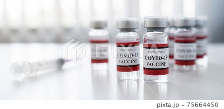 Covid-19 coronavirus vaccine bottle and syringe injection tool for covid19 immunization treatment on white table. Healthcare and Medical concept. Covid-19 coronavirus vaccine bottle and syringe injection tool for covid19 immunization treatment on white table. Healthcare and Medical concept. 75664450