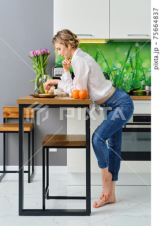 Woman dips toast in fried egg Woman dips toast in fried egg 75664837