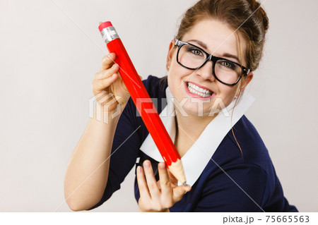 Smiling woman holds big pencil in hand 75665563