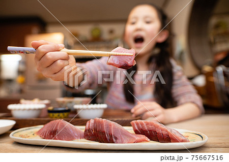 鰹の刺身を食べる女の子 75667516