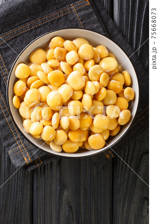Delicious Mediterranean lupine beans close-up in a bowl. Vertical top view 75668073