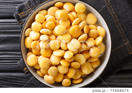 Salted yellow lupine beans close-up in a bowl. horizontal top view Salted yellow lupine beans close-up in a bowl. horizontal top view 75668074
