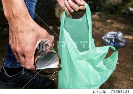 young man collecting garbage on the forest 75668183