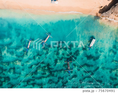 Sandy beach with turquoise ocean water and boats, aerial view 75670491