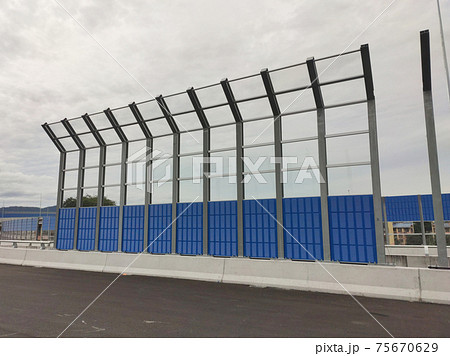 SELANGOR, MALAYSIA - JULY 2, 2020: Noise barriers are installed along the vehicle lane bordering the residence to prevent noise pollution to the locals. SELANGOR, MALAYSIA - JULY 2, 2020: Noise barriers are installed along the vehicle lane bordering the residence to prevent noise pollution to the locals. 75670629