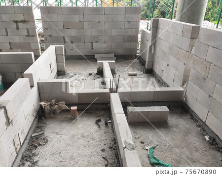 SEREMBAN, MALAYSIA -MARCH 15, 2020: Blockwork by construction workers at the construction site. Workers laying the AAC brick and stacked it together using mortar to form the wall.  75670890