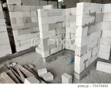 SEREMBAN, MALAYSIA -MARCH 15, 2020: Blockwork by construction workers at the construction site. Workers laying the AAC brick and stacked it together using mortar to form the wall.  75670892