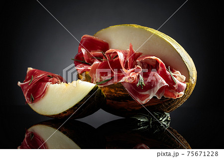 Prosciutto with melon and rosemary. Prosciutto with melon and rosemary. 75671228