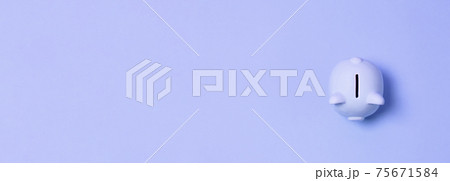 Cute piggy bank on a blue paper background. Saving and investment concept. Flat lay top view copy space Cute piggy bank on a blue paper background. Saving and investment concept. Flat lay top view copy space 75671584