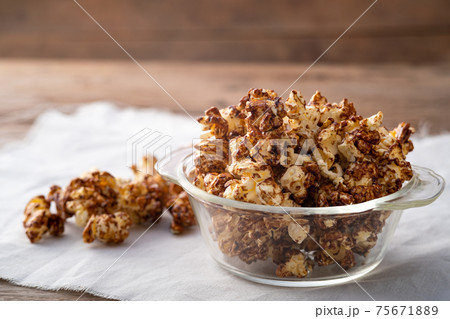 Chocolate popcorn in glass bowl on wooden table background 75671889