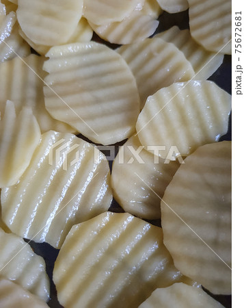 white potatoes, potatoes cut, sprinkled with oil and ready to bake food background, food and drink 75672681