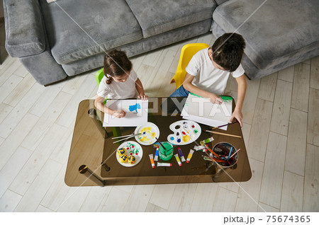 Boy and girl painting with watercolor paints. Children creativity class at home Boy and girl painting with watercolor paints. Children creativity class at home 75674365