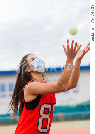 Portrait of tennis player girl holding racket outside with protective masks Portrait of tennis player girl holding racket outside with protective masks 75674705