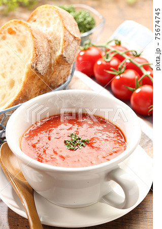 湯気が立つ食卓のトマトスープとパン 75674745