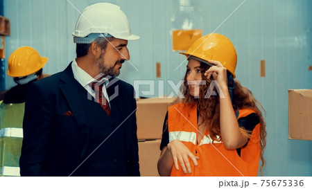 Warehouse senior manager talking to worker in the storehouse Warehouse senior manager talking to worker in the storehouse 75675336