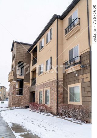 Multi storey apartment in a snowy neighborhood against white sky in winter Multi storey apartment in a snowy neighborhood against white sky in winter 75675600