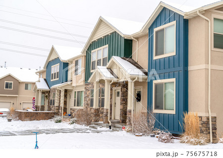 Snowy yard in front of apartment with colorful exterior wall and gabled entrance Snowy yard in front of apartment with colorful exterior wall and gabled entrance 75675718