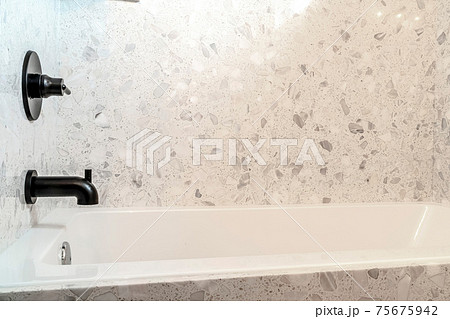 Built in bathtub and black faucet with single lever handle inside bathroom Built in bathtub and black faucet with single lever handle inside bathroom 75675942