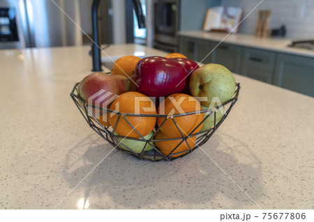 Wired geometric fruit basket with fresh fruits at the kitschen island of home Wired geometric fruit basket with fresh fruits at the kitschen island of home 75677806