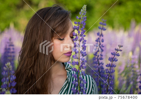 beautiful girl eyes closed Leans Head Against Lupin flower on blooming meadow beautiful girl eyes closed Leans Head Against Lupin flower on blooming meadow 75678400