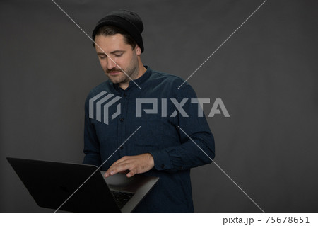 Handsome mustached unshaven guy in knitted cap Communicating in social networks Handsome mustached unshaven guy in knitted cap Communicating in social networks 75678651