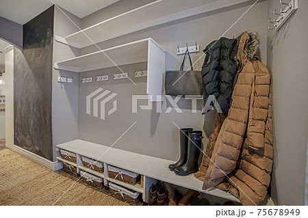 Walk in closet with clothes bag and shoes on the built in shelves and hangers 75678949