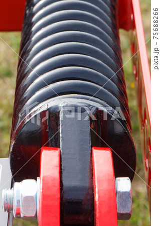 Hard black spring made of steel. Part and detail of industrial or agricultural machine 75688266