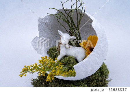 Decoration for Easter, a lamb in broken egg shell decorated with flowers. Decoration for Easter, a lamb in broken egg shell decorated with flowers. 75688337