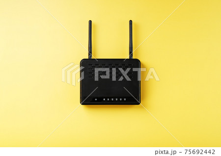 Black Wi-Fi router on a yellow background with free space. Black Wi-Fi router on a yellow background with free space. 75692442