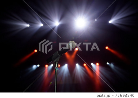 Close-up of microphone at concert against blur colorful light background 75693540