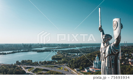 Aerial view to the Beautiful landscape city Kiev with a Dnepr river. Top view to the Motherland statue in the Kiev. The well-known landmarks in Kyiv. Historical monument of Soviet union. . Aerial view to the Beautiful landscape city Kiev with a Dnepr river. Top view to the Motherland statue in the Kiev. The well-known landmarks in Kyiv. Historical monument of Soviet union. . 75693934