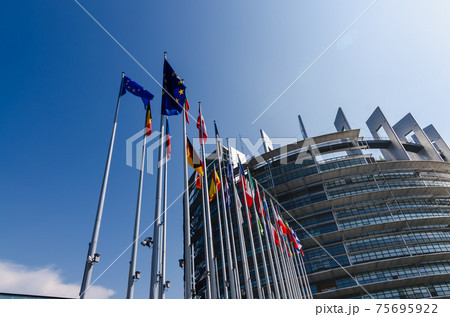 Strasbourg, France. August 2019.The entrance to the modern seat of the European parliament. A row of flagpoles with the flags of the member states of the European Union welcomes those who enter. 75695922