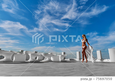 The young woman in white pareo on a terrace and blue sky on a background 75697050
