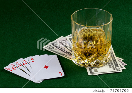 Playing Cards with Cash and Drink on a Felt Table Top 75702706