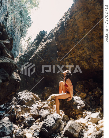 Slim brunette woman in bikini posing at sandy beach. Tanned female model at vacations Slim brunette woman in bikini posing at sandy beach. Tanned female model at vacations 75702713
