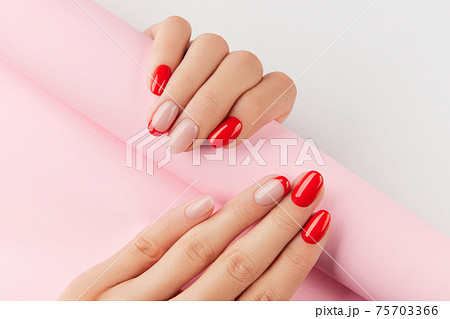 Womans hands with red modern manicure over white background. Manicure design trends Womans hands with red modern manicure over white background. Manicure design trends 75703366