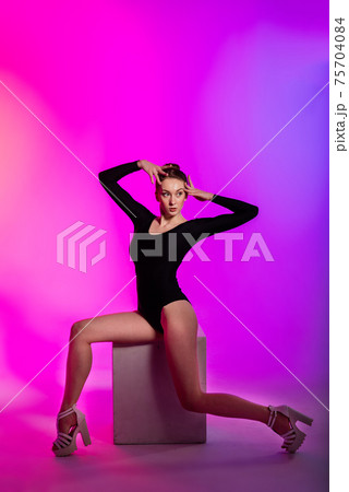 Beautiful young woman wearing sexy high heels and black clothes while dancing in pole dance studio Beautiful young woman wearing sexy high heels and black clothes while dancing in pole dance studio 75704084