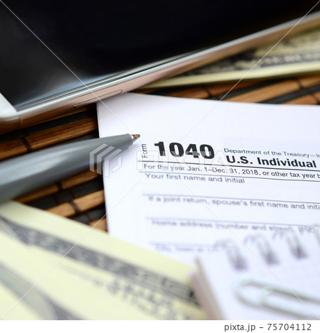 The pen, notebook, smartphone and dollar bills is lies on the tax form 1040 U.S. Individual Income Tax Return. The time to pay taxes The pen, notebook, smartphone and dollar bills is lies on the tax form 1040 U.S. Individual Income Tax Return. The time to pay taxes 75704112