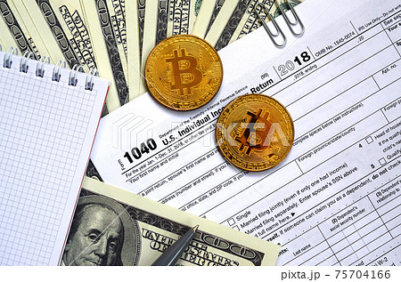 The pen, bitcoins and dollar bills is lies on the tax form 1040 U.S. Individual Income Tax Return. The time to pay taxes The pen, bitcoins and dollar bills is lies on the tax form 1040 U.S. Individual Income Tax Return. The time to pay taxes 75704166