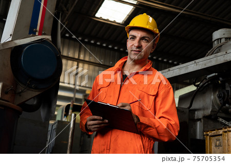 Skillful factory worker working with clipboard to do job procedure checklist . Skillful factory worker working with clipboard to do job procedure checklist . 75705354