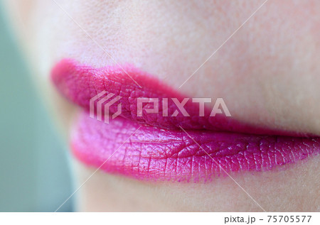 Close up shot of woman lips with glossy fuchsia lipstick Close up shot of woman lips with glossy fuchsia lipstick 75705577